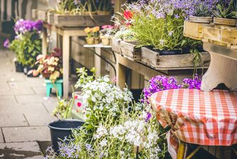 Terrasse oder Gehsteig mit Blumen, ev. Geschäft mit Auslage